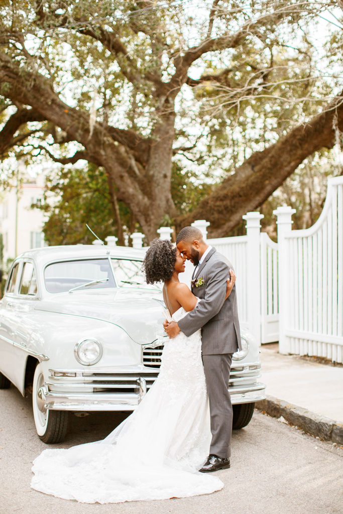luxury bride and groom with vintage getaway car