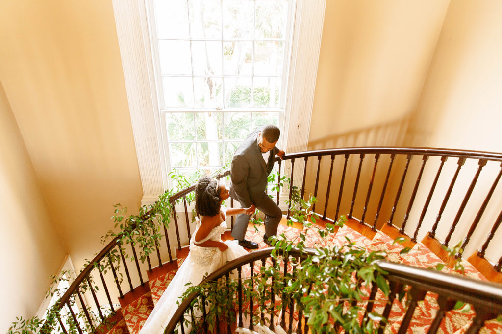 luxury bride and groom portrait on grand staircase with florals